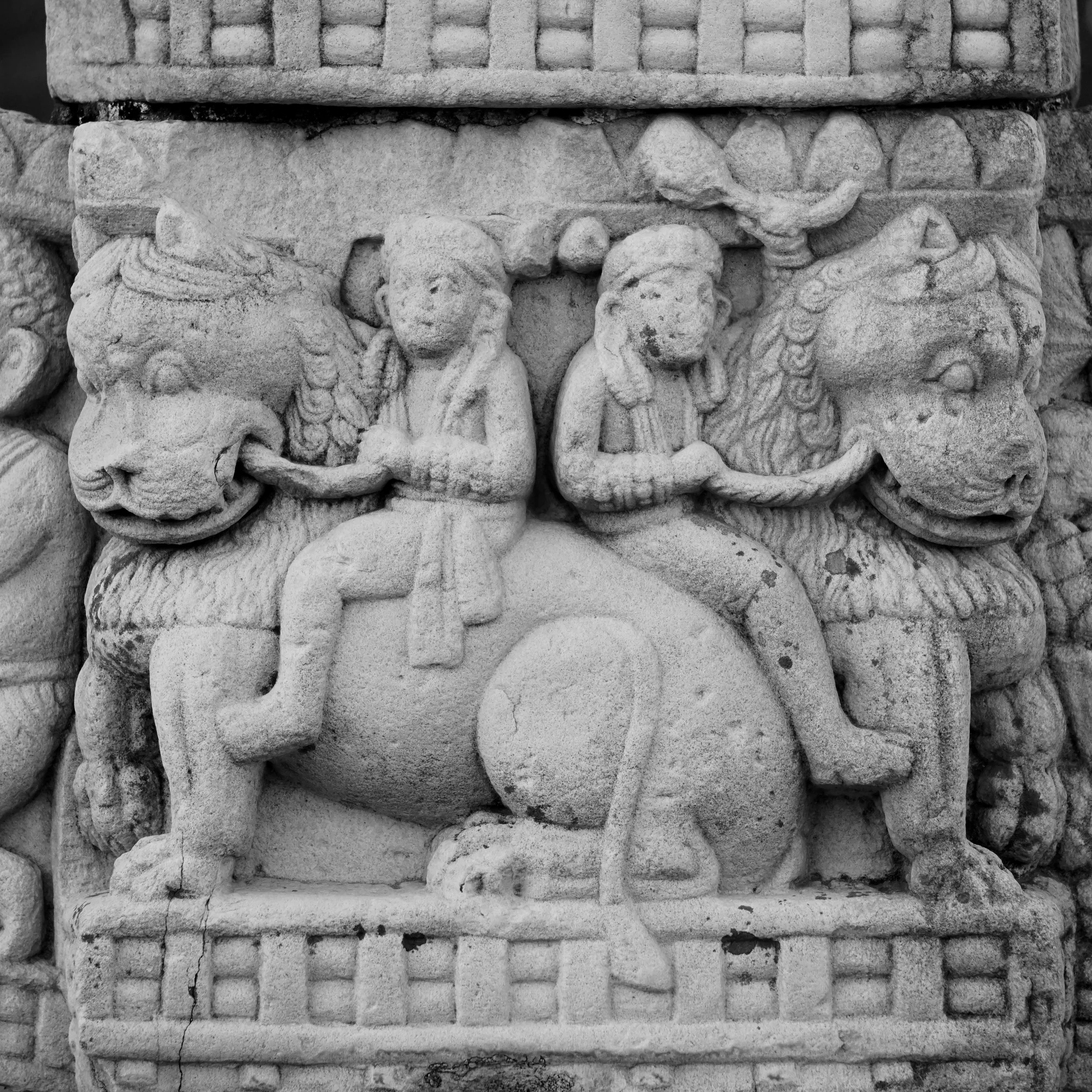 Carved relief of men riding lions