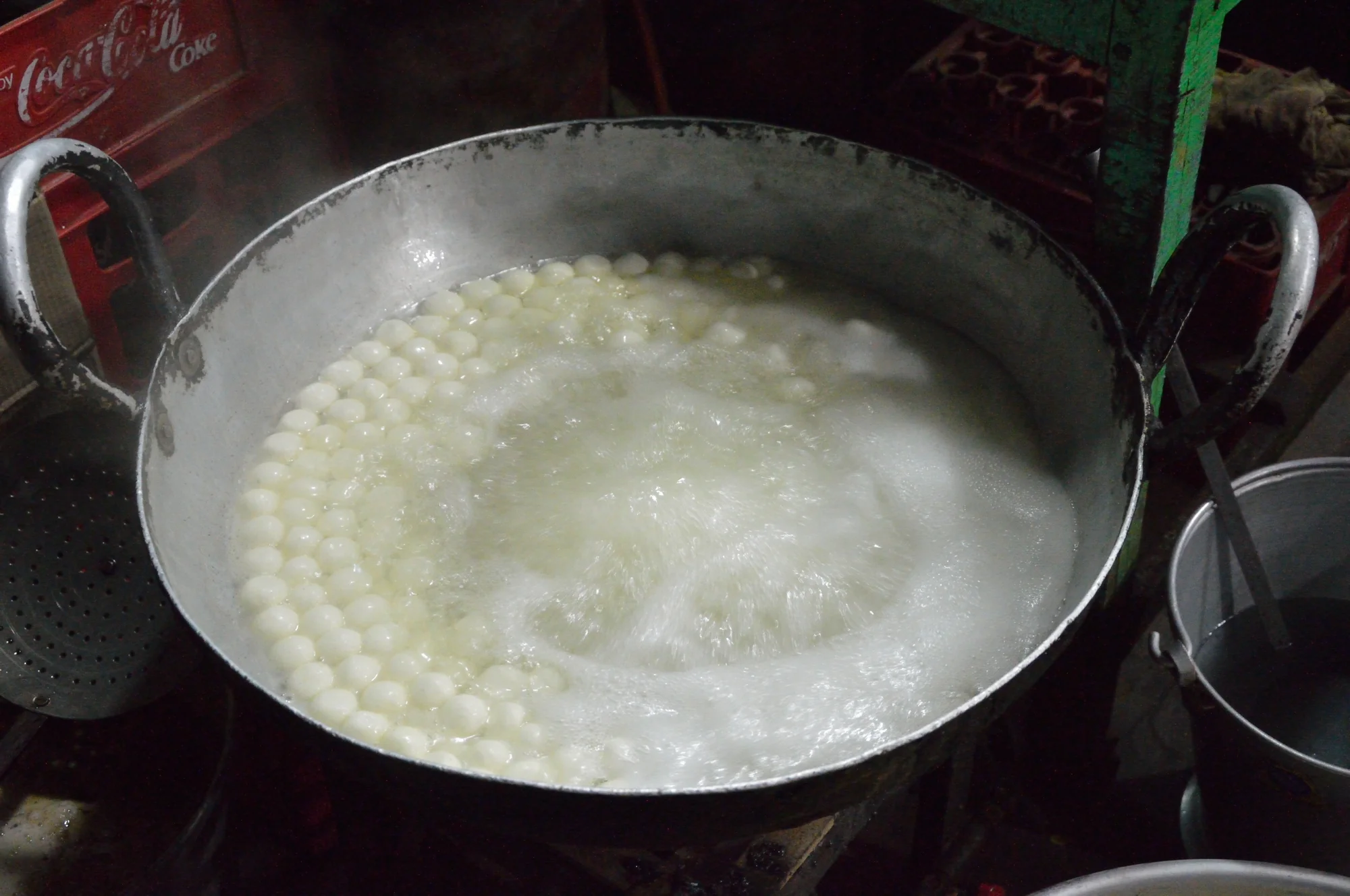 Rasgulla being cooked in boiling syrup
