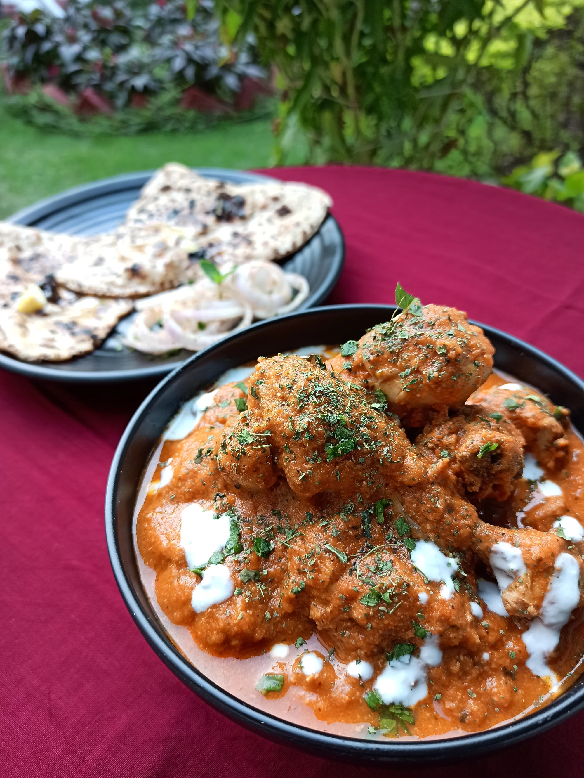 Butter chicken served with butter naan in a traditional home setting