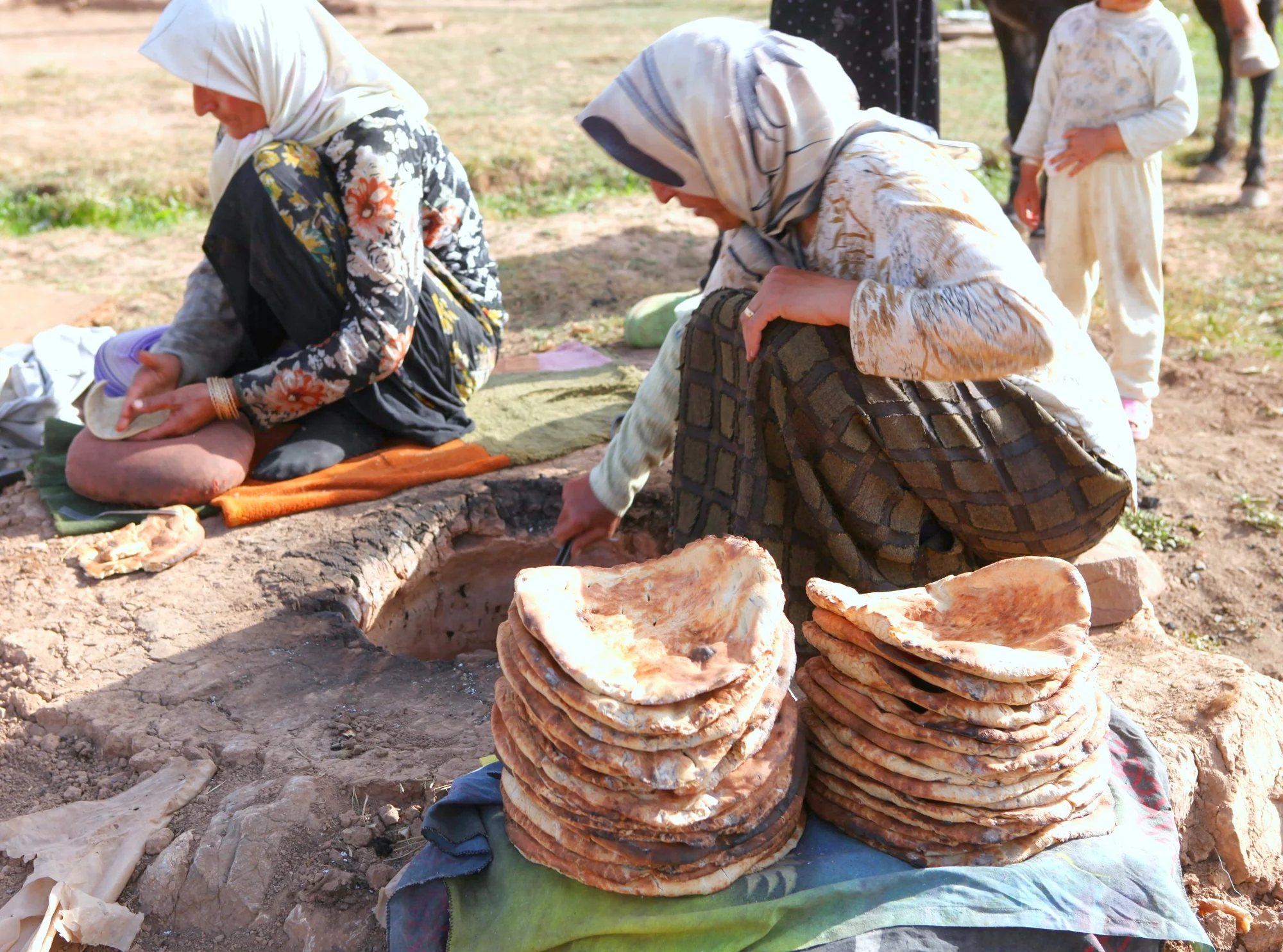 Nomad women baking traditional bread in Lar National Park
