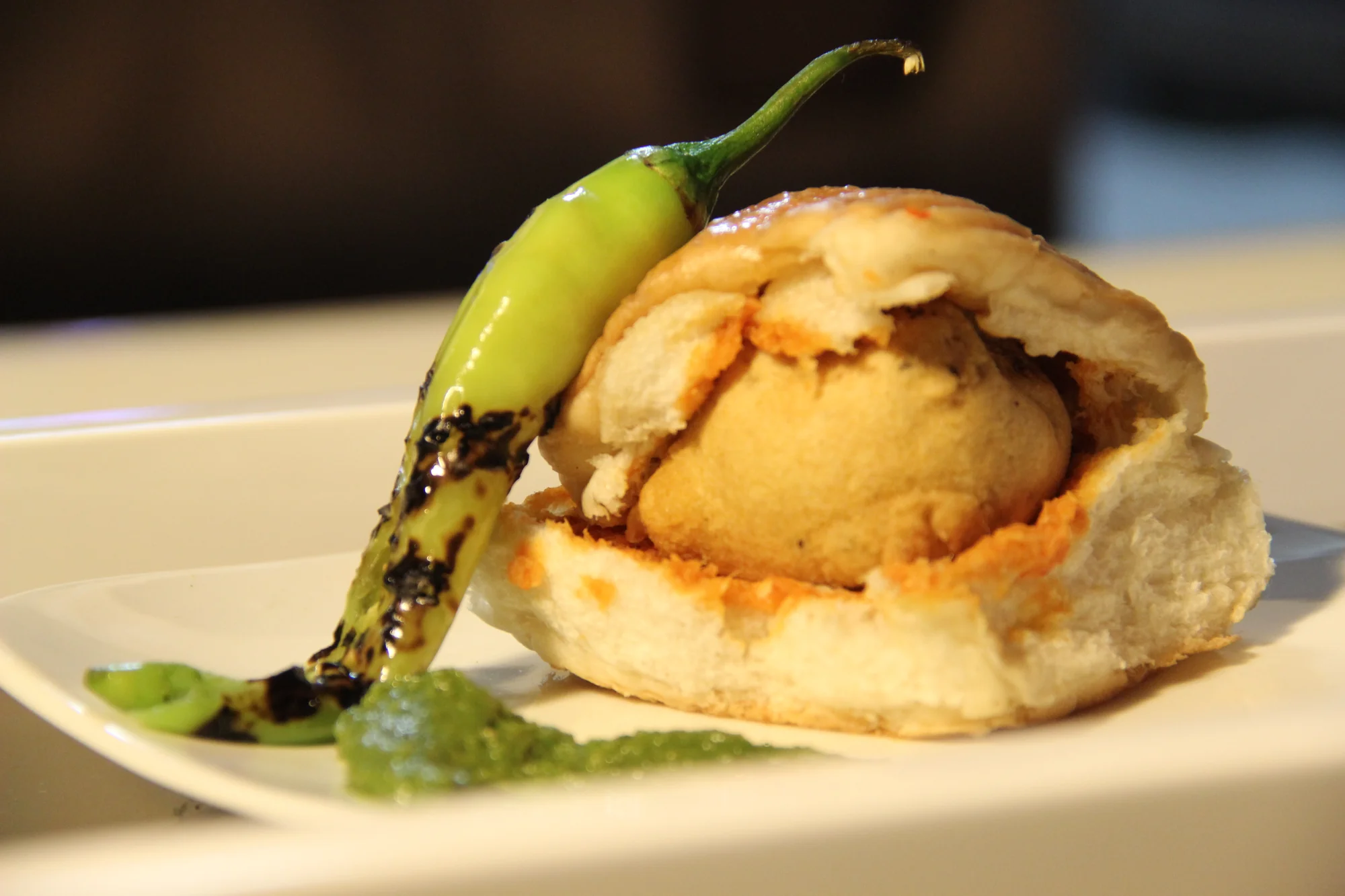 Close-up of Vada Pav showing the potato vada inside the pav