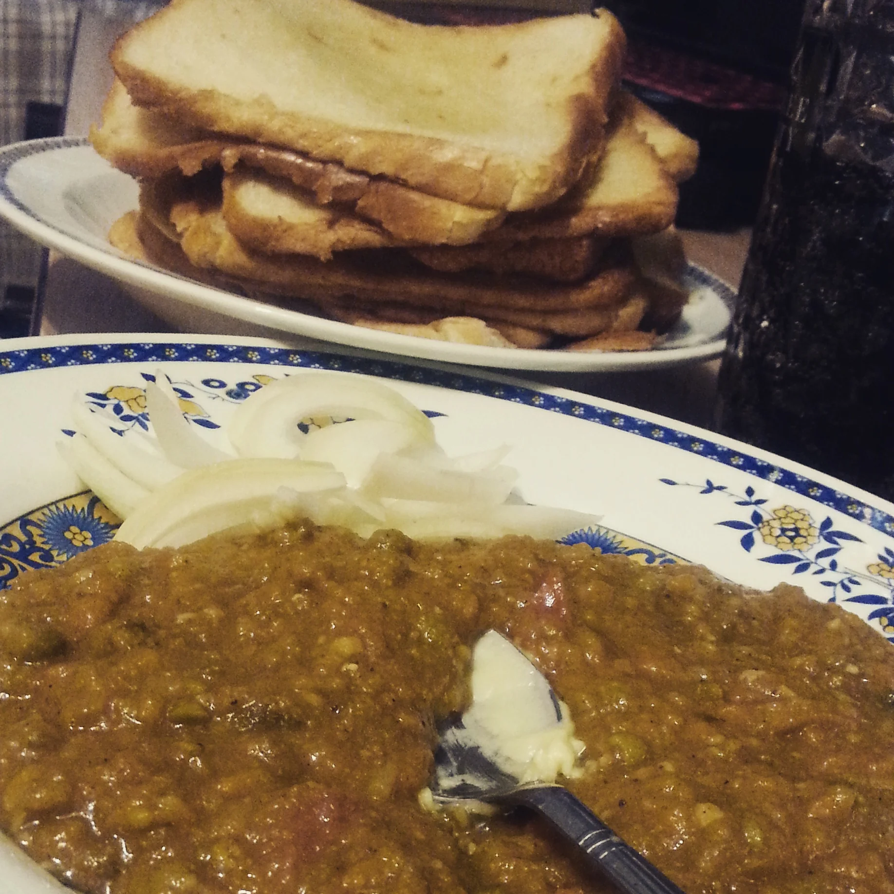 Close-up view of pav bhaji with visible vegetables and butter melting on top
