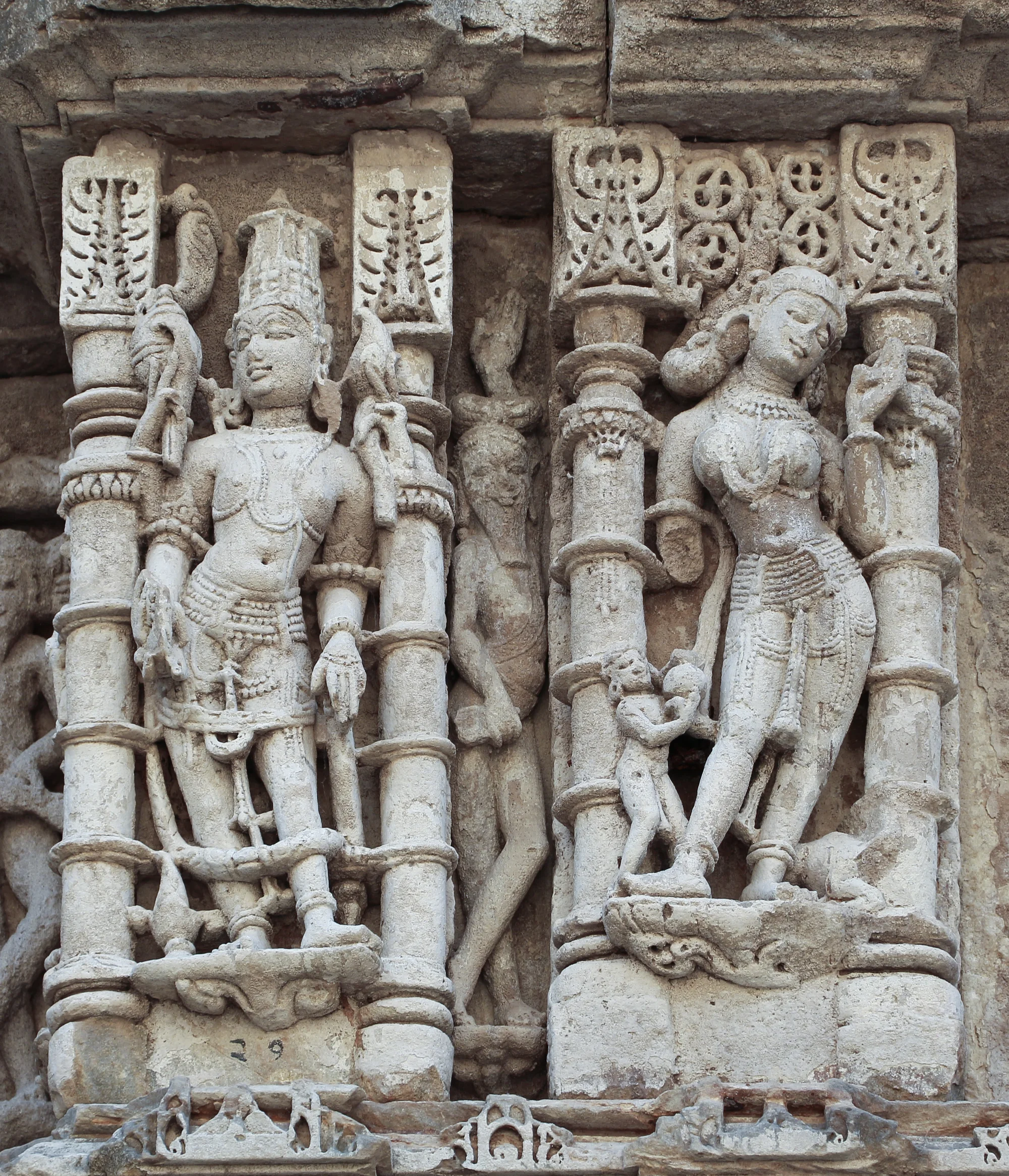 Detailed sculptures carved on pillars showing Hindu deities and ornamental designs